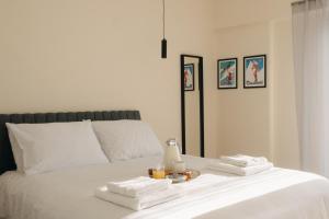 a white bed with towels and a candle on it at Patras Skyline Suite in Patra