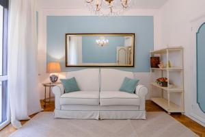a living room with a white couch and a mirror at Ponte Vecchio Escape Suite in Florence