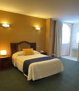 una camera da letto con un cuscino arancione di Hoteli Alifer Tlaxcala X TECAL LIVING a Tlaxcala de Xicohténcatl