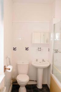 a white bathroom with a toilet and a sink at THE CHADWICK in Skegness