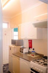 a kitchen with a stove and a white refrigerator at THE CHADWICK in Skegness