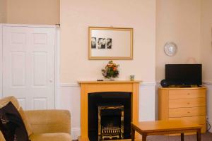 a living room with a fireplace and a television at THE CHADWICK in Skegness