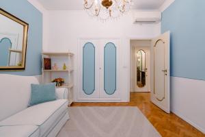 een woonkamer met een witte bank en een kroonluchter bij Ponte Vecchio Escape Suite in Florence