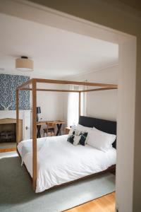 a bedroom with a canopy bed with white sheets and pillows at Canandaigua Guesthouse in Canandaigua