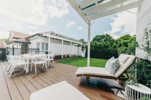 a deck with a table and chairs on it at Urban Getaway Bardon Luxe 3 bed 2 bath and pool in Brisbane