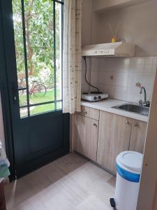 a small kitchen with a door and a sink at Niriton Pension in Nydri