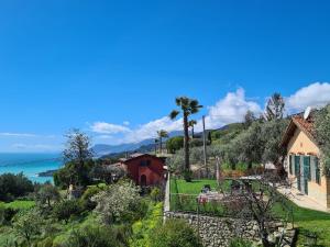 a house on a hill with the ocean in the background at Casa Ulivi e Mare in Ventimiglia