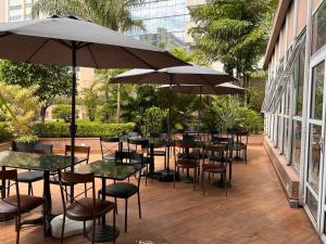 un patio avec des tables, des chaises et des parasols dans l'établissement Ótimo flat Jardins SP entre Av. Paulista e Pq. Ibirapuera., à São Paulo
