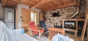 a living room with a fireplace and a red chair at Quinta de Sito in Chantada