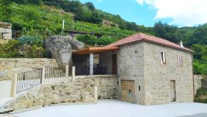 a small stone building in front of a mountain at Quinta de Sito in Chantada