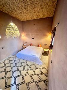 ein Schlafzimmer mit einem Bett in einem Zimmer in der Unterkunft Dar Talmoudi in Tagounite
