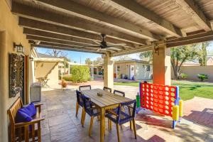 un patio con mesa de madera y sillas en Spacious Uptown Phoenix Home with Pool and Yard Games! en Phoenix