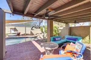 a patio with chairs and a table next to a pool at Spacious Uptown Phoenix Home with Pool and Yard Games! in Phoenix