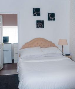 a bedroom with a large white bed with two pictures on the wall at THE CHADWICK in Skegness