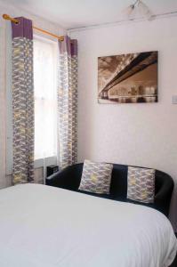 a bedroom with a white bed and a couch at THE CHADWICK in Skegness