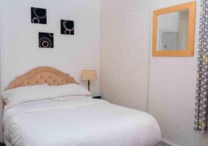 a bedroom with a white bed and a mirror at THE CHADWICK in Skegness