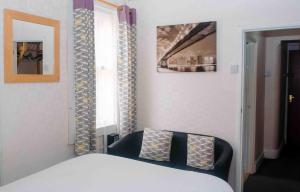a bedroom with a bed and a chair and a window at THE CHADWICK in Skegness