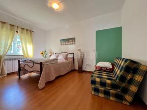 ein Schlafzimmer mit einem Bett, einem Sofa und einem Stuhl in der Unterkunft Terra Mista Alojamento Local in Gouveia