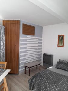 a bedroom with a bed and a chair and a television at Monseñor Fagnano 592 "6" in Ushuaia