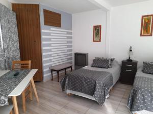 1 dormitorio con 2 camas, mesa y escritorio en Monseñor Fagnano 592 "6" en Ushuaia