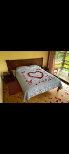 Una cama con rosas rojas en un dormitorio en Terra Encantada, en Maranura