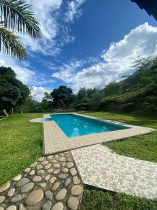 a swimming pool in the middle of a grassy field at Terra Encantada in Maranura