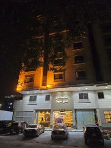 ein Gebäude mit Autos, die vor einem Geschäft geparkt sind in der Unterkunft سحابة الأحلام - Dream Cloud Hotel in Dschidda