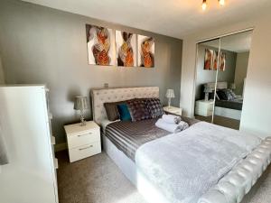 a bedroom with a white bed and a mirror at Bright & Spacious-Secured flat near slough station in Slough