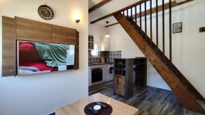 a living room with a large tv and a staircase at Bobija Village Skadar lake in Karuč