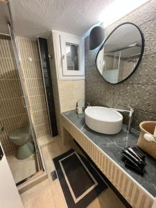 La salle de bains est pourvue d'un lavabo et d'un miroir sur un comptoir. dans l'établissement Secret Colors of Thessaloniki, à Thessalonique
