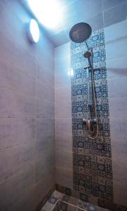 y baño con ducha y pared de azulejos. en Villa jamal essaouira, en Essaouira