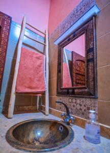 ein Bad mit einem Waschbecken und einem Spiegel in der Unterkunft Villa jamal essaouira in Essaouira