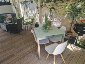 einen Tisch und Stühle in einem Zimmer mit Pflanzen in der Unterkunft Gîte L'instant Cocooning in Baie-Mahault