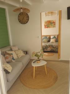 ein Wohnzimmer mit einem Sofa und einem Tisch in der Unterkunft Gîte L'instant Cocooning in Baie-Mahault