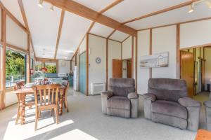 a kitchen and dining room with a table and chairs at Finlay Waterfront - Waikawa Holiday Home in Picton