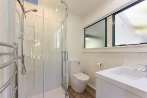 a bathroom with a shower and a toilet and a sink at Finlay Waterfront - Waikawa Holiday Home in Picton +15 photos