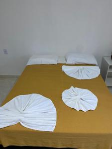 twee bedden met witte lakens en kussens erop bij Quatro Estações in Mata de Sao Joao