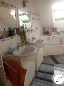 een badkamer met 2 wastafels en een bad bij Casa Maria in Weingarten