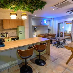 a kitchen and living room with a counter and chairs at Hidden Garden of Kallithea in Athens +18 photos