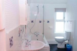 a white bathroom with a sink and a toilet at THE CHADWICK in Skegness