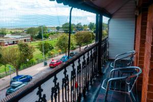 a balcony with chairs and cars parked on a street at THE CHADWICK in Skegness