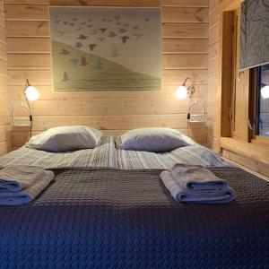 uma cama grande com duas almofadas e toalhas em Fabulous Villa with beautiful lake views em Huutotöyry
