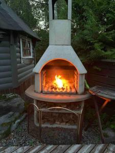 um forno exterior com um fogo dentro dele em Fabulous Villa with beautiful lake views em Huutotöyry
