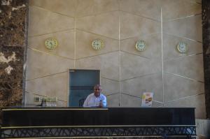 a man sitting at a desk with clocks on the wall at Scandic resort in Hurghada +267 photos