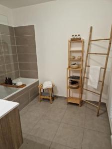 ein Badezimmer mit einer Badewanne, einem Waschbecken und einem Regal in der Unterkunft Cozy apartment near Paris in Clamart