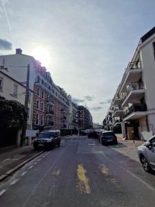 eine leere Stadtstraße mit geparkten Autos und Gebäuden in der Unterkunft Cozy apartment near Paris in Clamart