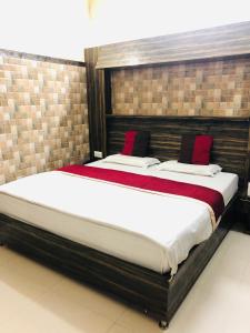 - une chambre avec un grand lit et des oreillers rouges dans l'établissement Vidya hotel, à Katra
