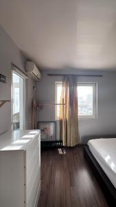 Camera bianca con letto e finestra di CozyNest Apartments a Tirana