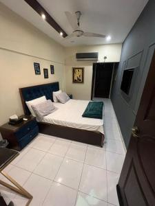 1 dormitorio con cama, mesita de noche y sidx sidx sidx sidx sidx en Cottage Hotel, en Karachi