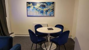 una sala de reuniones con mesa y sillas azules en Garland Modern Spacious Flat, London, en Londres